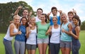 Were committed to fitness. A happy group of young people smiling at the camera while standing on a sportsfield. Royalty Free Stock Photo