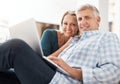 Were connected. Portrait of an affectionate mature couple using a laptop while sitting on the sofa together at home. Royalty Free Stock Photo