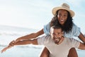 Were flying in to a fun-filled summer. Portrait of a young man piggybacking his girlfriend at the beach. Royalty Free Stock Photo