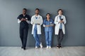 Were here so you can face another day. a group of doctors standing against a grey background at work.