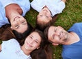 Were just a bunch of peas in a pod. Portrait of a cheerful family lying on the ground together outside in a park during Royalty Free Stock Photo