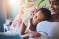 Were just going to relax today. Portrait of an adorable little girl relaxing with her mother while she reads her a story Royalty Free Stock Photo