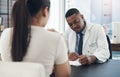 Were just going to take down some general information. a young male doctor talking to a patient in an office. Royalty Free Stock Photo