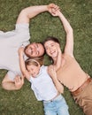 Were one happy family. High angle shot of a young family lying on the grass in their garden at home and bonding. Royalty Free Stock Photo