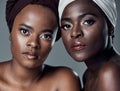 Were proud of our cultural background. Studio portrait of two beautiful young women posing against a grey background. Royalty Free Stock Photo