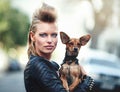 Were so rock n roll. Cropped portrait of an edgy young woman holding her small dog outdoors.