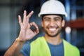 Were 100 safety compliant. Portrait of a young man working showing an okay gesture at a construction site. Royalty Free Stock Photo