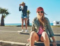 Were spending the summer beach boarding. two friends hanging out on the boardwalk with a skateboard. Royalty Free Stock Photo