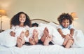 Were staying in but still having fun. Portrait of two adorable little children relaxing in bed with their parents at Royalty Free Stock Photo