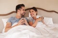 Were staying in today. a happy young couple drinking coffee in bed in their bedroom at home. Royalty Free Stock Photo