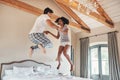 Were taking a leap of faith together. Full length sho of a playful young couple jumping on bed together at home. Royalty Free Stock Photo