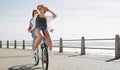 Were taking a trip to the fun side of life. Full length shot of a happy young couple riding a bicycle together on a Royalty Free Stock Photo