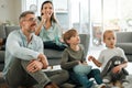 Were watching our favourite movie. a young family watching tv together at home.