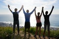 Were working on bettering ourselves. a group of people raising their hands in victory while out exercising.