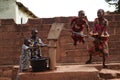 West African Children Filling Up A Water Bucket At The Borehole Royalty Free Stock Photo