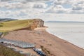 08-29-2020 West Bay, UK. View from clifftop at a golden beach with people enjoying walking and coastline of West Bay. Royalty Free Stock Photo