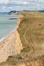 08-29-2020 West Bay, UK. View from clifftop at a golden beach with people enjoying walking and coastline of West Bay Royalty Free Stock Photo