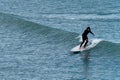 One man in a waterproof suit is surfing. Water sports. Man in black wet suit surfing on sea