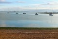 West Mersea beach with line of bobbing boats in the estuary. Royalty Free Stock Photo