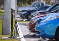 WEST PALM BEACH, FL - February 18, 2018: A blue electric or hybrid car is plugged into a charging station in West Palm Beach, FL.