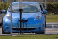 WEST PALM BEACH, FL - February 18, 2018: A blue electric or hybrid car is plugged into a charging station in West Palm Beach, FL. Royalty Free Stock Photo