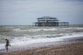 West Pier, Brighton, England - the structure and a girl on the beahc. Royalty Free Stock Photo