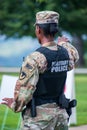 Black woman military police officer wearing a camouflage uniform and bulletproof vest directing traffic