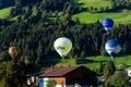 Westendorf, Tirol/Austria - September 27 2018: Four different hot-air balloons flying low over the houses and hills of Westendorf