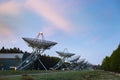 The Westerbork Synthesis Radio Telescope WSRT during dusk, with a light cloudy sky and stars a little visible