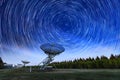 The Westerbork Synthesis Radio Telescope WSRT during dusk, with a light cloudy sky and stars a little visible