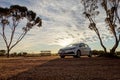 WESTERN AUSTRALIA - JULY 1, 2018: Travelling through the Australian outback with a white Toyota Corolla car in a beuatiful sunrise Royalty Free Stock Photo