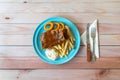 BBQ pork ribs, onion rings, french fries and coleslaw in blue plate on table Royalty Free Stock Photo