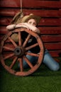 Western girl in cowboy hat sitting with wagon wooden wheel. Royalty Free Stock Photo