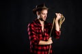 Western life. Man unshaven cowboy black background. Man wearing hat hold rope. Lasso tool of American cowboy. Lasso is Royalty Free Stock Photo