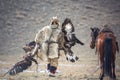 Western Mongolia, Golden Eagle Festival. The Mongolian Nomad Bears Two Golden Eagles In His Hands After The `Fox Skin` Competition