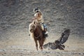 Western Mongolia, Hunting With Golden Eagle. Young Mongolian Girl - Hunter On Horseback Participating In The Golden Eagle Festival