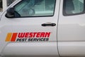 A Western Pest Services truck parked at the side of a street in front of several houses