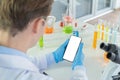 A western scientist man holding blank space smartphone, working on test tube to analysis and develop vaccine of covid-19 virus in