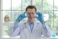 A western scientist man using hologram tablet with copy space to analysis and develop vaccine of covid-19 virus in lab or