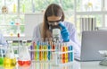 A western scientist woman working on test tube to analysis and develop vaccine of covid-19 virus in lab or laboratory in