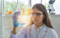 A western scientist woman working on test tube to analysis and develop vaccine of covid-19 virus in lab or laboratory in