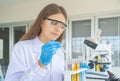 A western scientist woman working on test tube to analysis and develop vaccine of covid-19 virus in lab or laboratory in