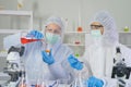 A western scientists couple working on test tube to analysis and develop vaccine of covid-19 virus in lab or laboratory in