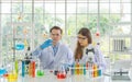 A western scientists couple working on test tube to analysis and develop vaccine of covid-19 virus in lab or laboratory in Royalty Free Stock Photo
