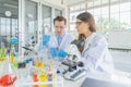 A western scientists couple working on test tube to analysis and develop vaccine of covid-19 virus in lab or laboratory in Royalty Free Stock Photo