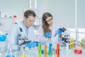 A western scientists couple working on test tube to analysis and develop vaccine of covid-19 virus in lab or laboratory in Royalty Free Stock Photo