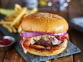 Western style bacon burger with onion rings and bbq sauce close up Royalty Free Stock Photo