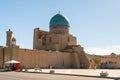 Western wall of Kalyan mosque with ancient walls and big colorful dome against blue sky