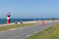 Lighthouse at dike with passing bikers near Westkapelle, the Netherlands Royalty Free Stock Photo