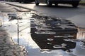 wet asphalt after heavy rainstorm, with puddles and reflections visible